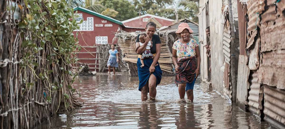 Mulheres caminham em meio a inundação causada pela enchente em Madagáscar